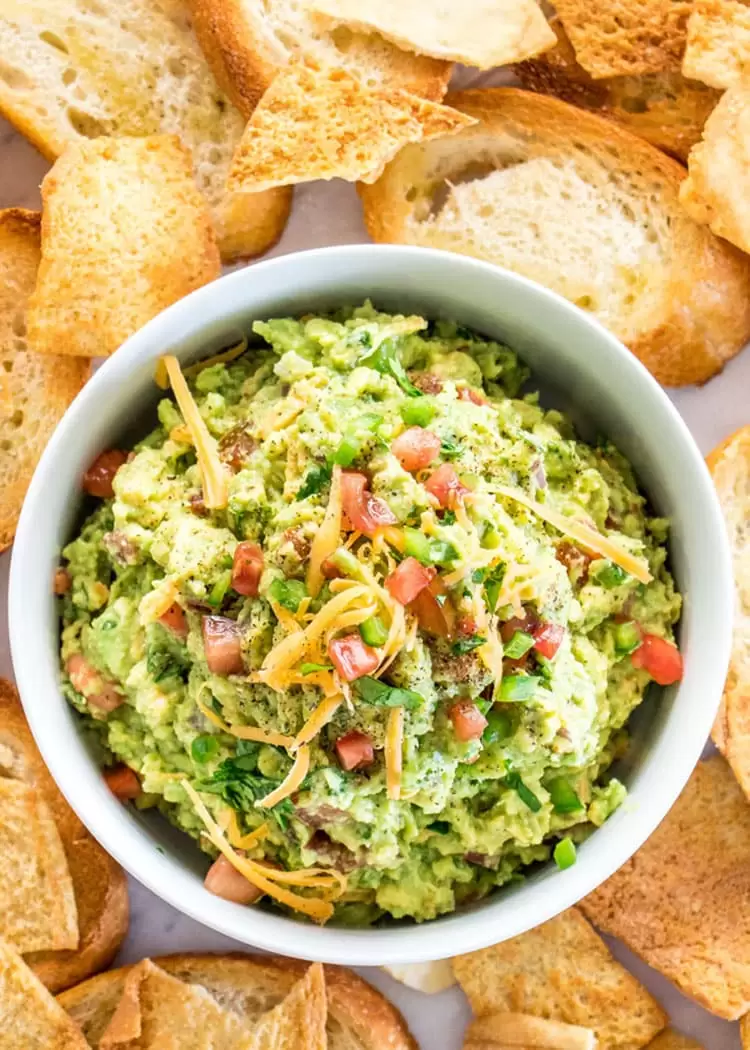 This Cheesy Guacamole might be the best guacamole you'll ever have. It's chunky, perfect combination of flavors with some cheddar cheese thrown in, and super easy to make. It's the perfect last-minute appetizer, ready in only 10 minutes. 