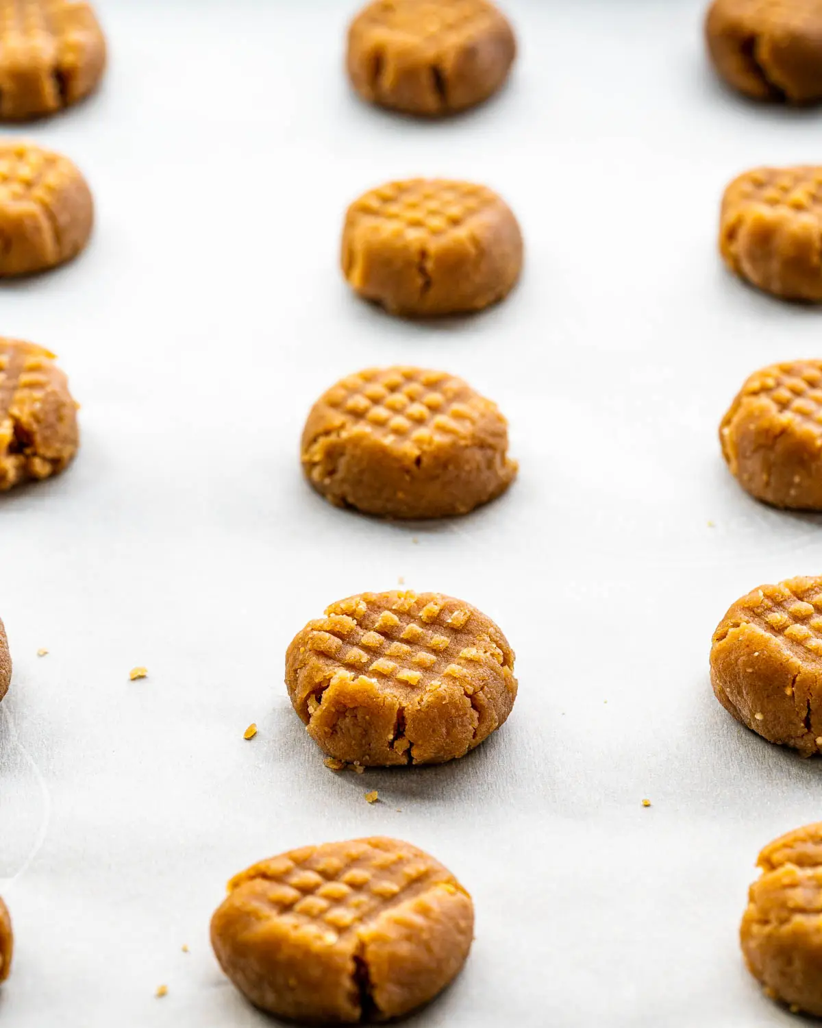 peanut butter cookies on a baking sheet ready to go in the oven.