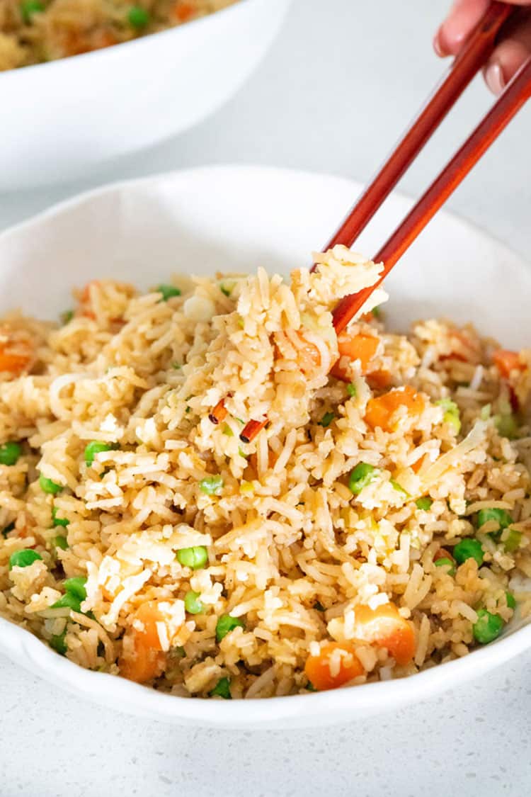 Super quick and Easy Fried Rice in less than 10 minutes. This fried rice is very versatile, made with egg, any other protein can be added such as shrimp or chicken. #friedrice