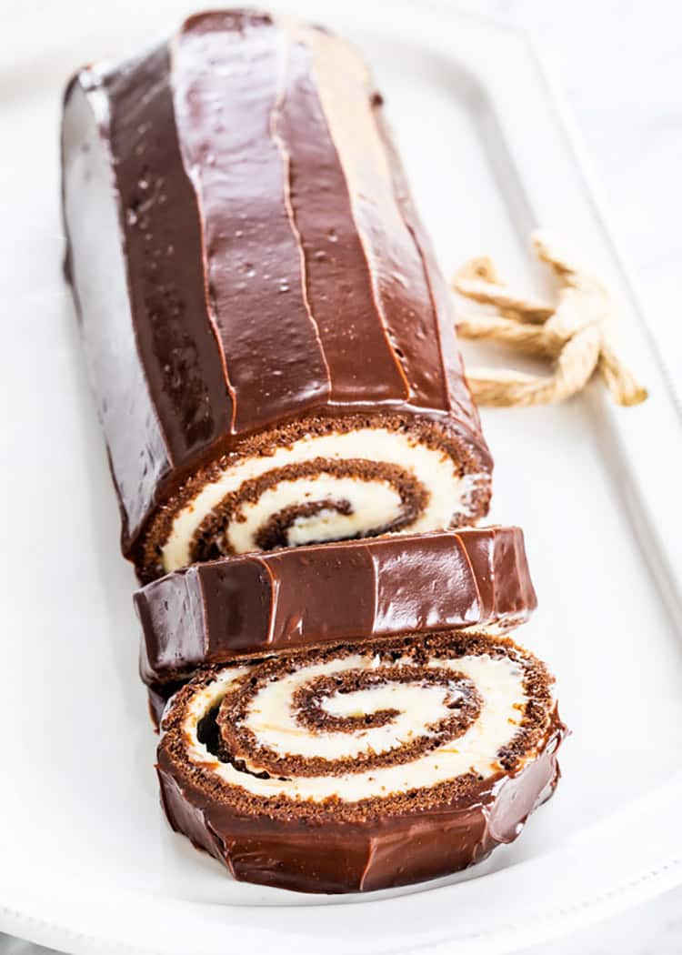 chocolate swiss roll cake on a white platter