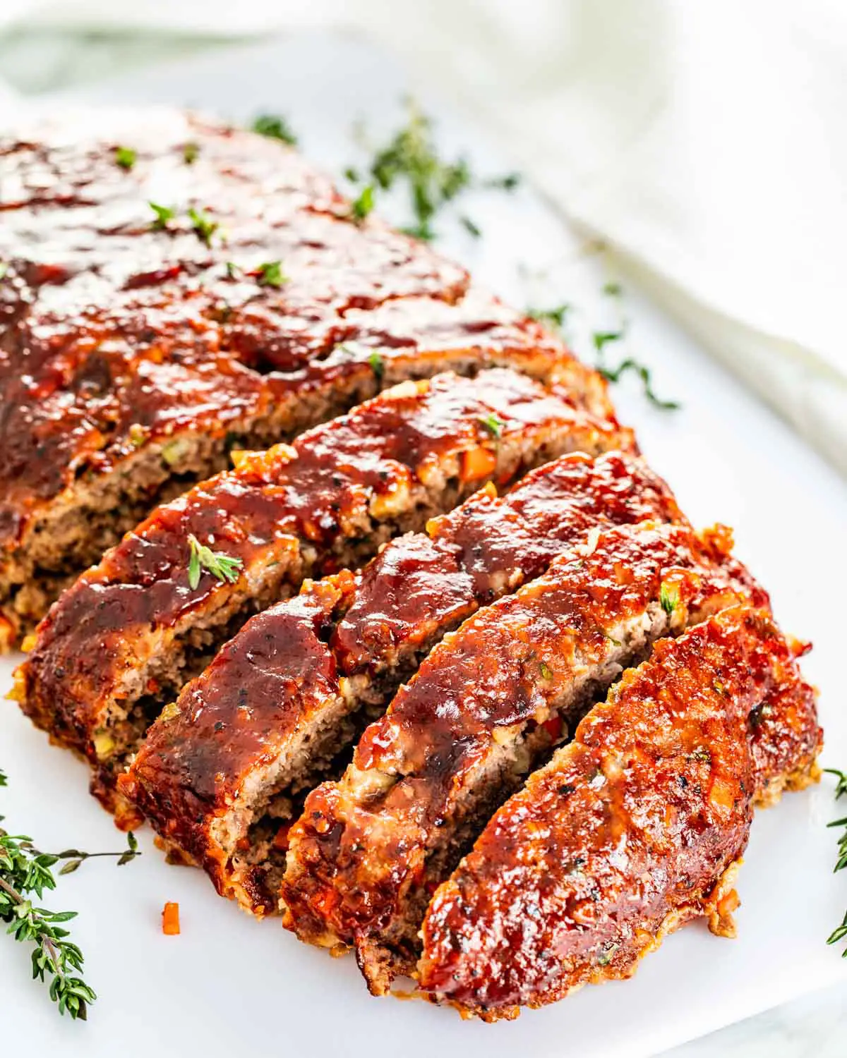 meatloaf sliced on a white cutting board.