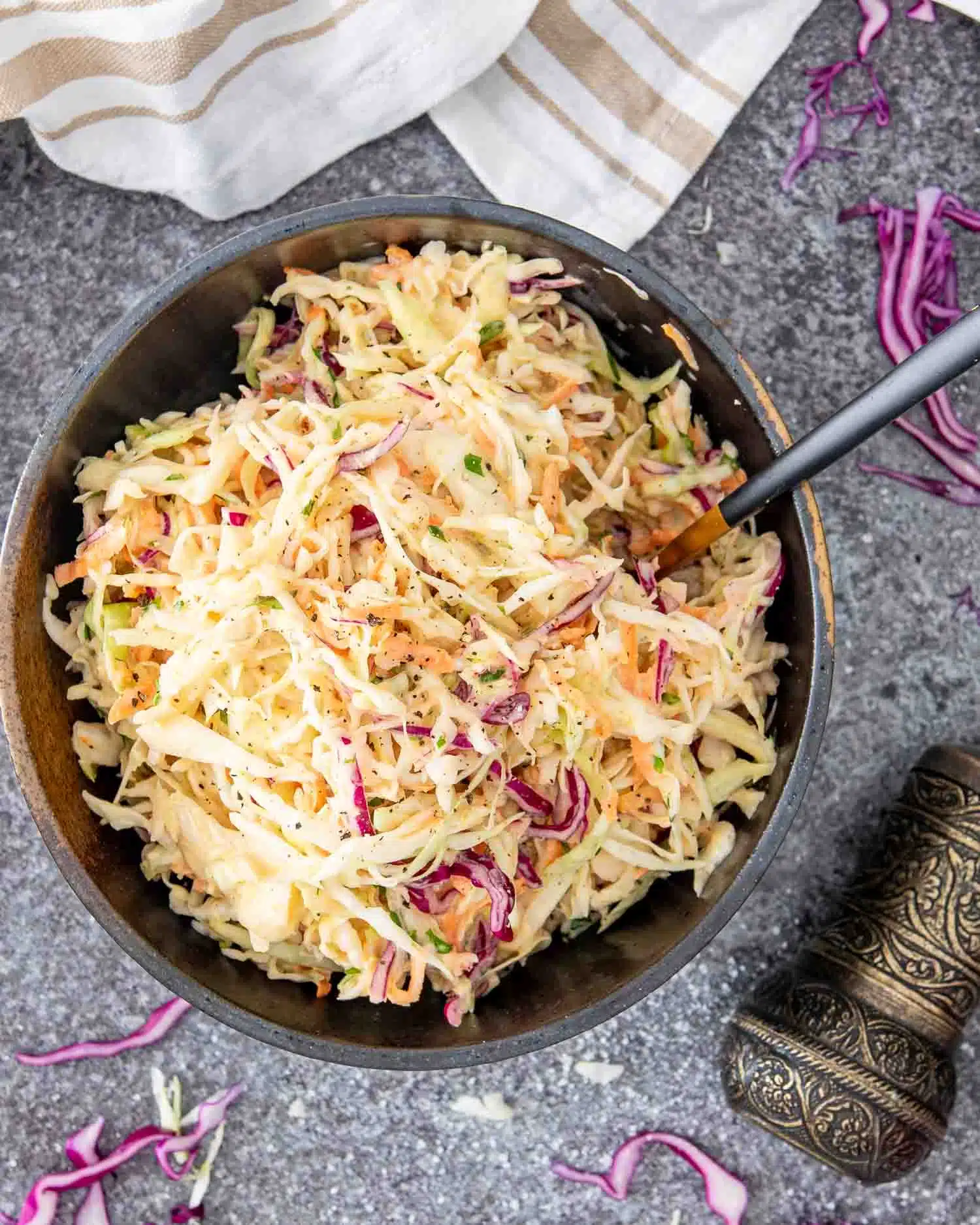 a serving of freshly made coleslaw in a brown bowl.
