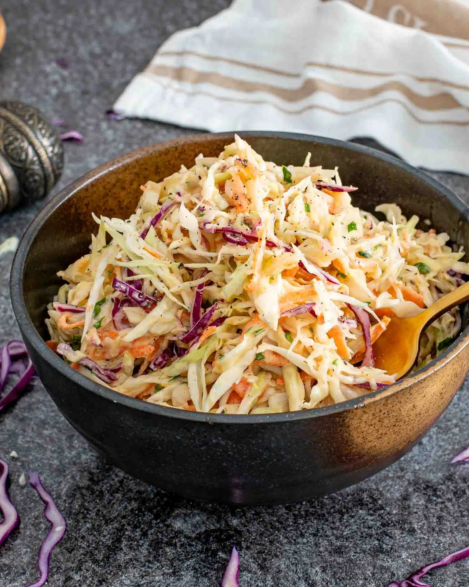 a serving of freshly made coleslaw in a brown bowl.