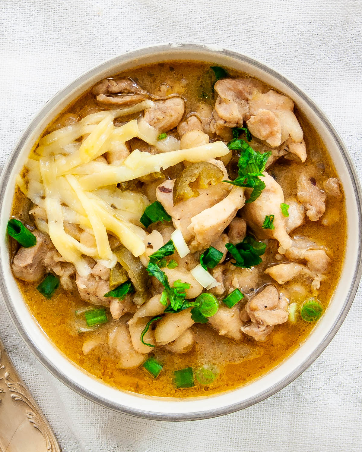 overhead shot of a bowl loaded with white chicken chili