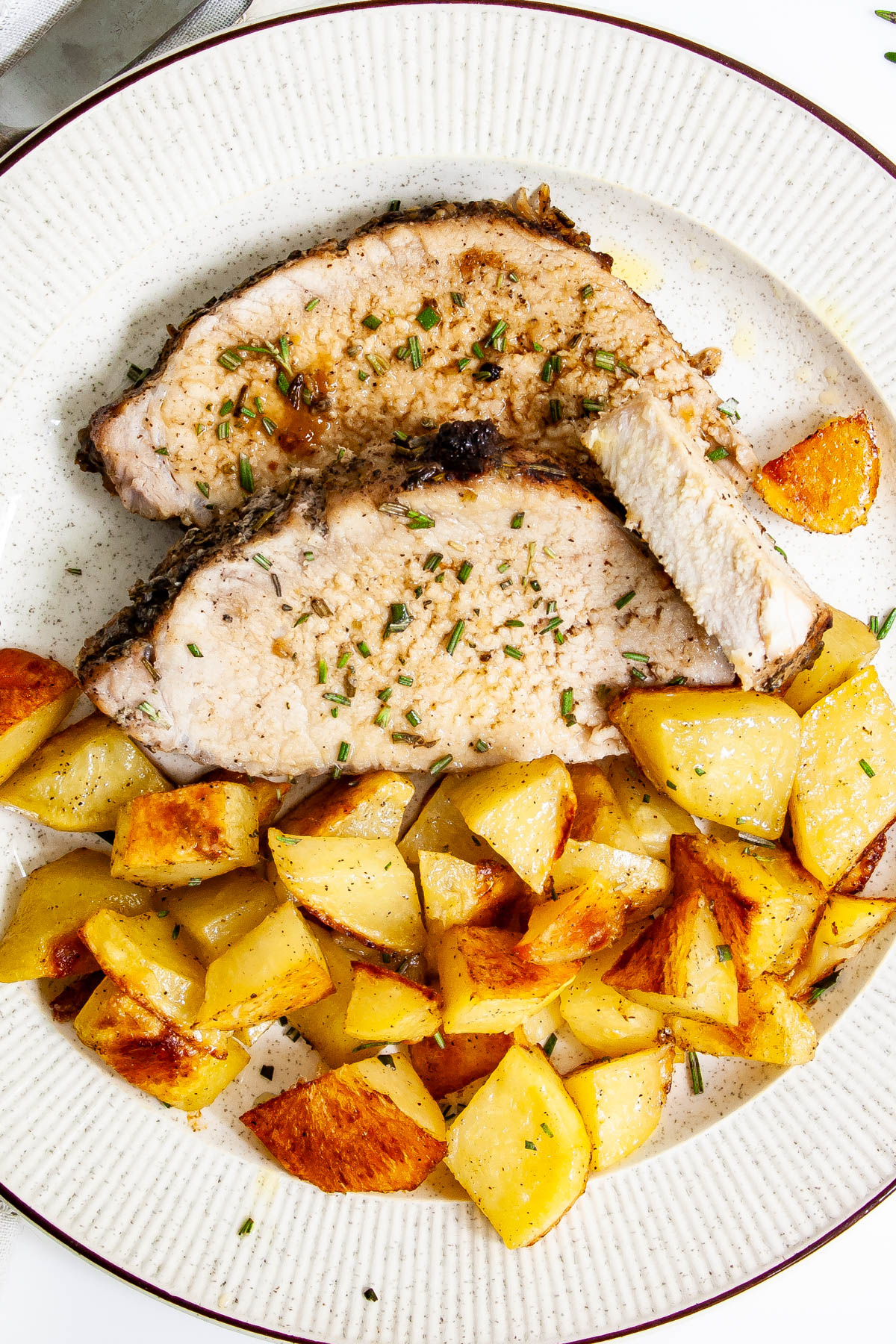 Pork Loin Roast slices with roasted potatoes on a plate
