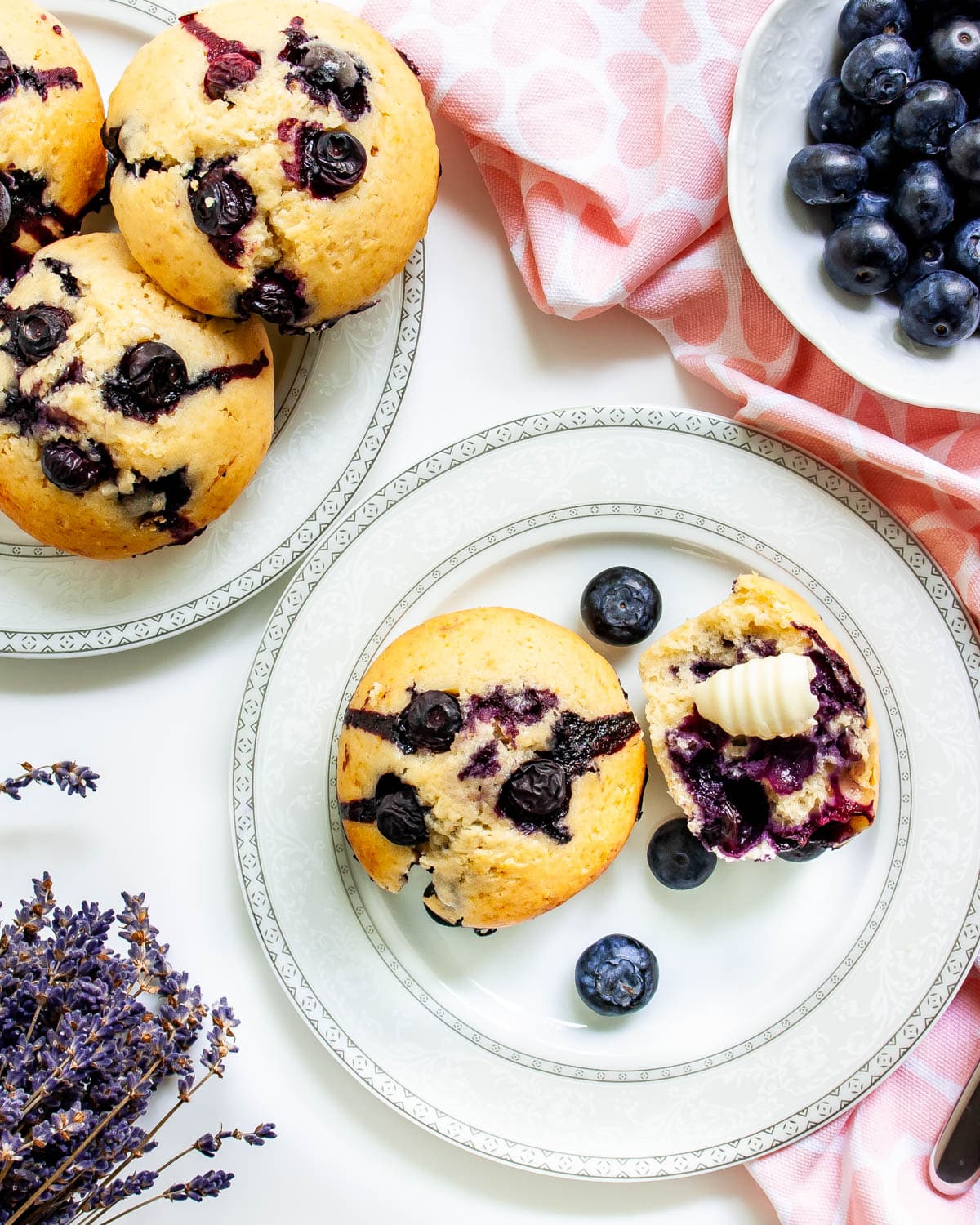 two white plates with blueberry muffins on them