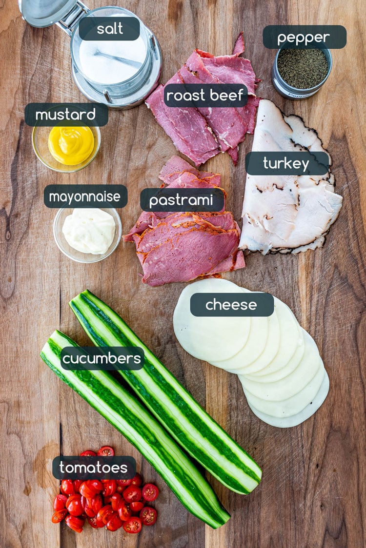 Ingredients needed to make cucumber sandwiches laid on a wooden board