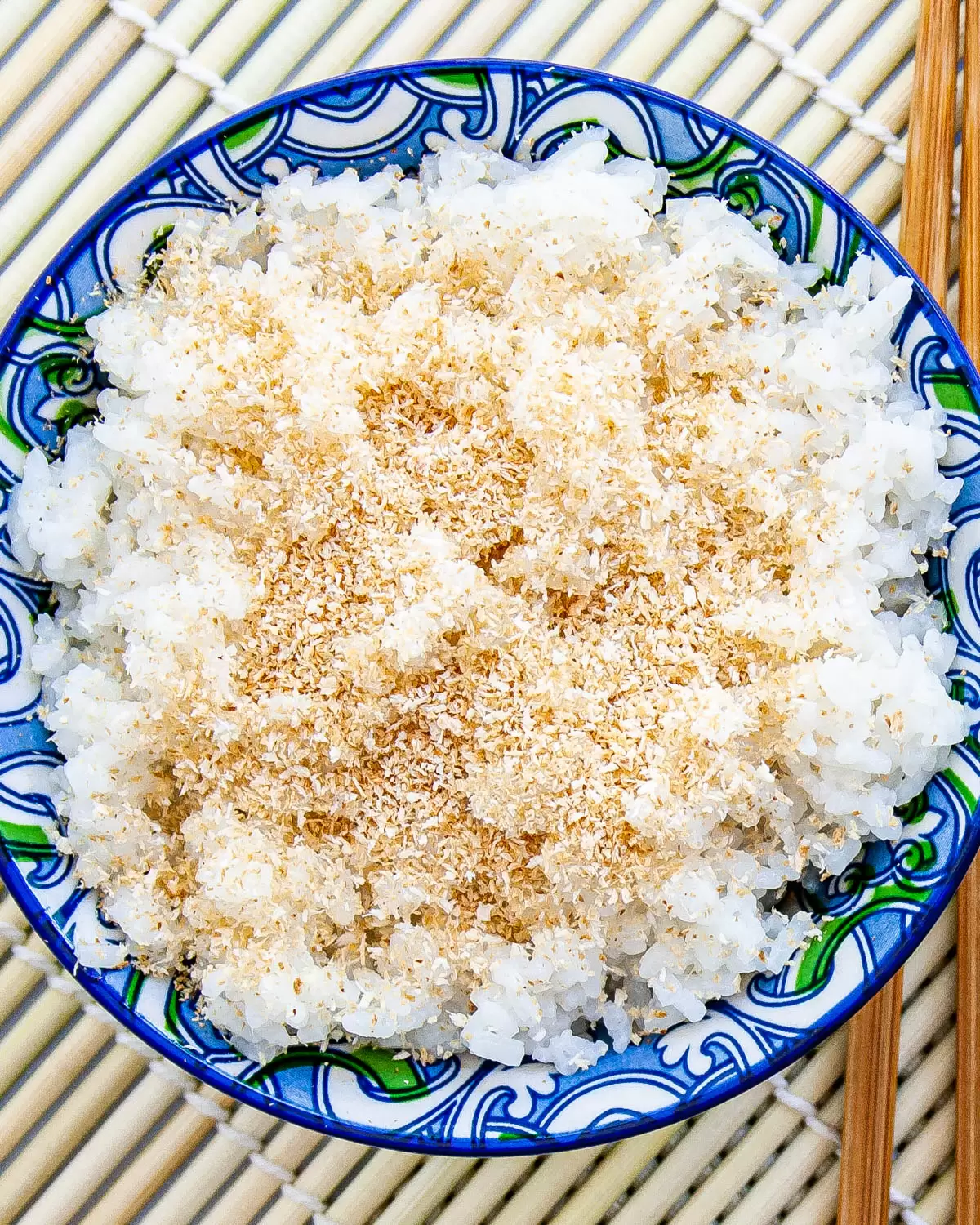 overhead shot of coconut rice in a bowl garnished with toasted coconut
