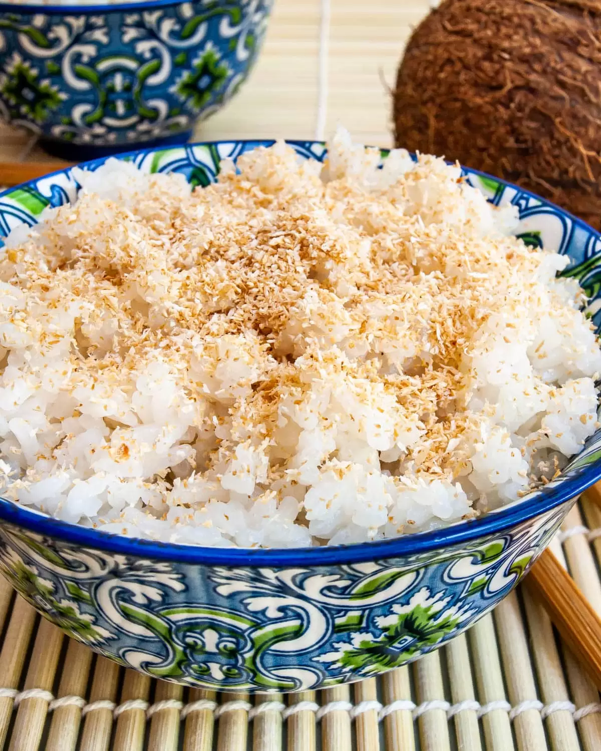 coconut rice in a blue bowl garnished with toasted coconut