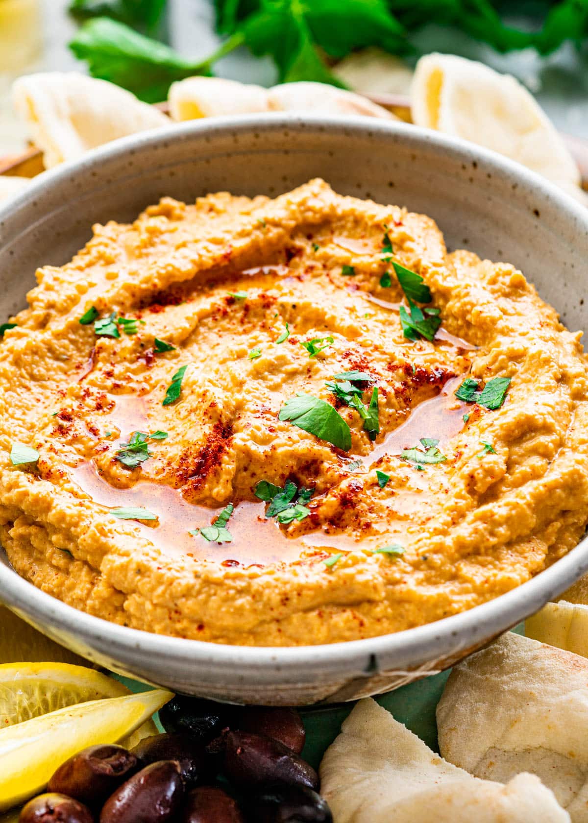 hummus in a bowl garnished with parsley and olive oil