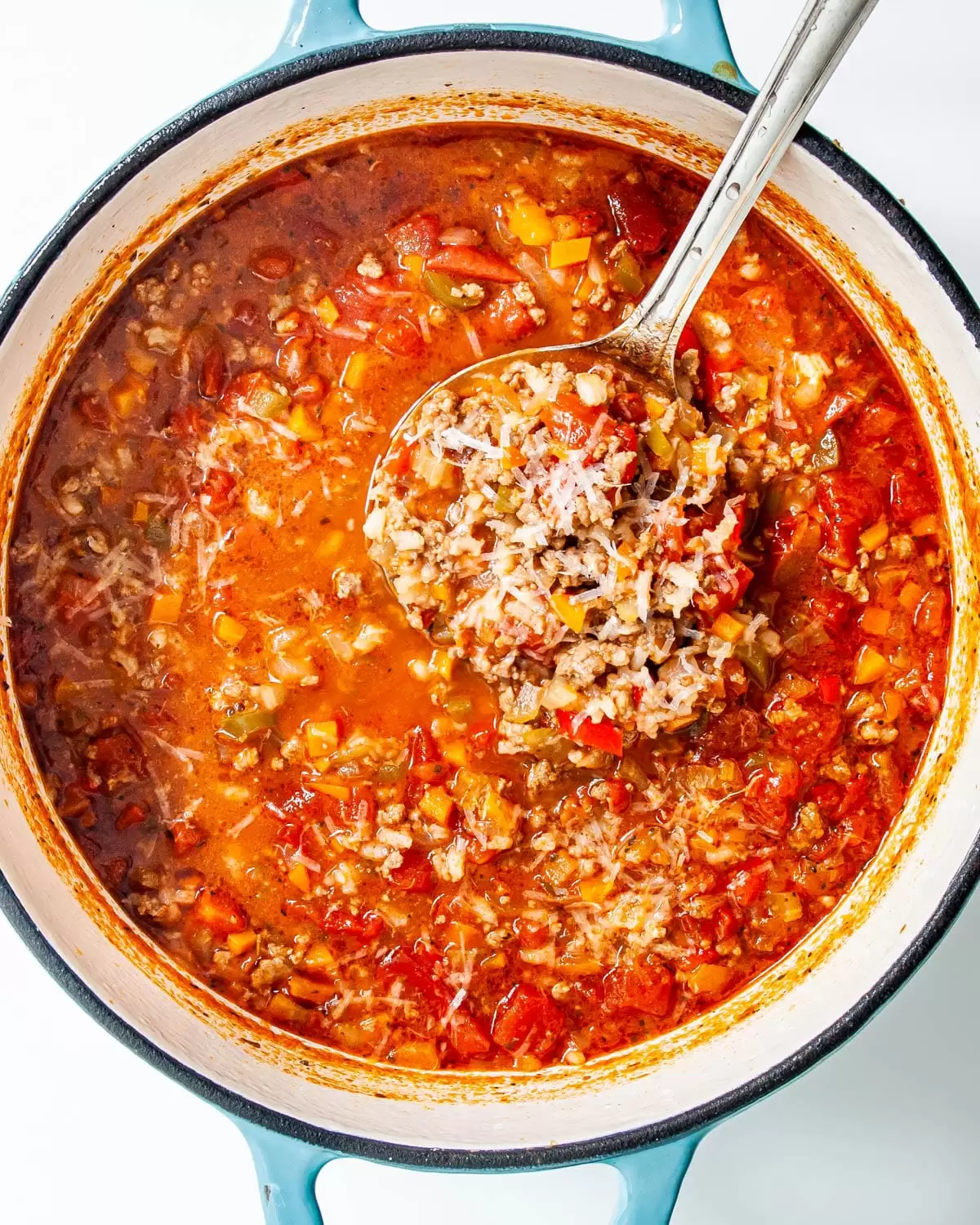 stuffed pepper soup in a large dutch oven with a ladle full of soup over it