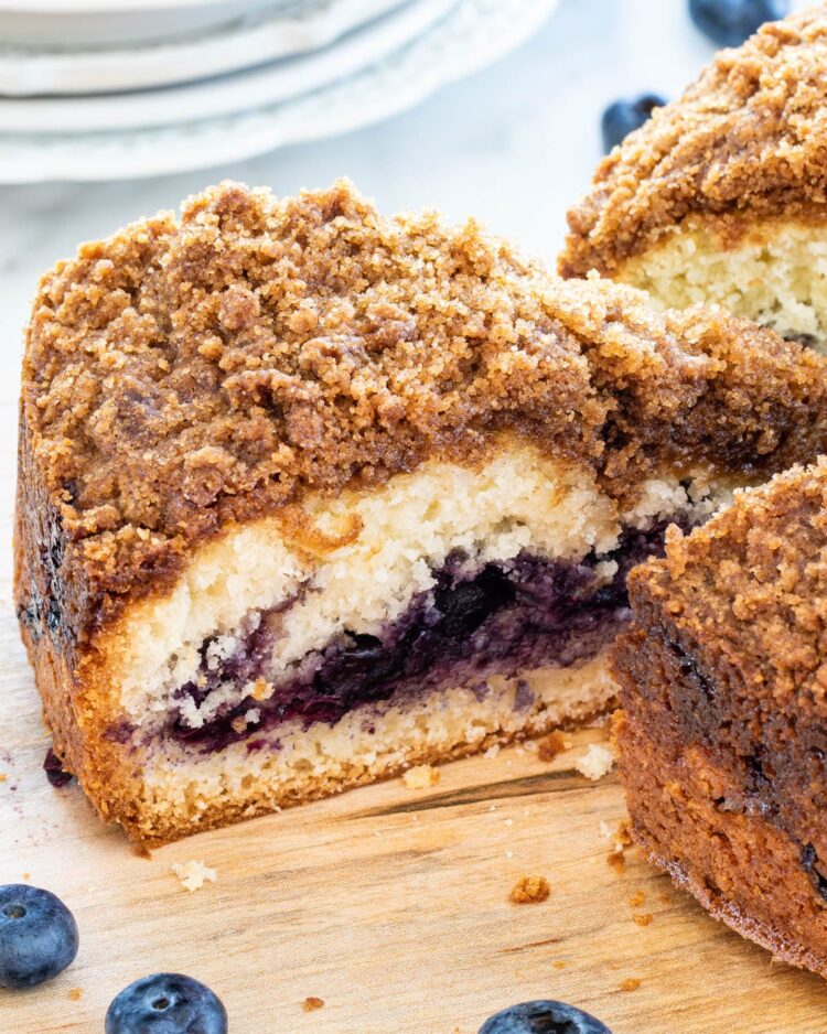 a slice of blueberry coffee cake on a cutting board