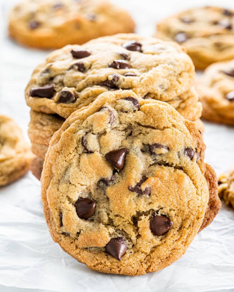a chocolate chip cookie leaning on a stack of cookies