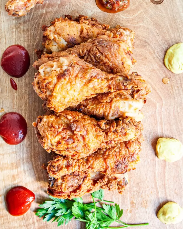overhead shot of fried chicken drumsticks on a cutting board
