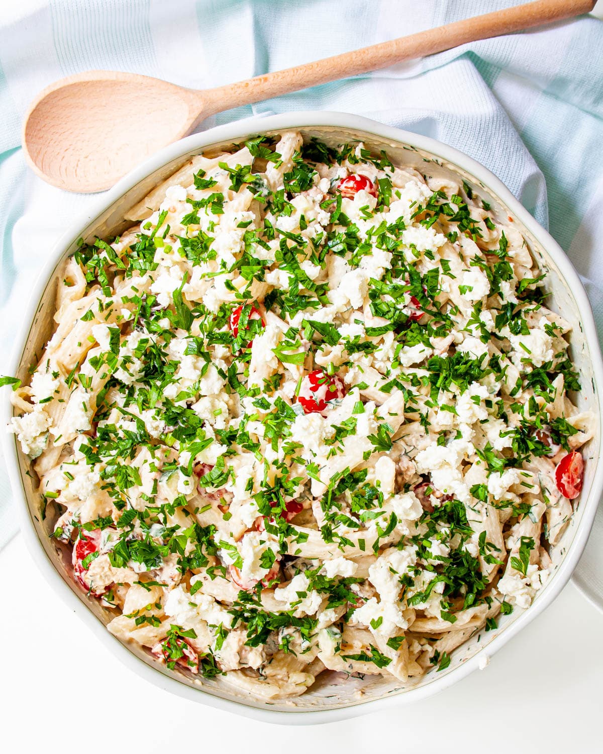 overhead shot of a large bowl loaded with greek chicken pasta garnished with parsley