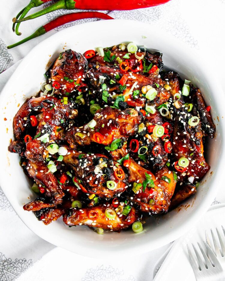 overhead shot of honey soy chicken wings in a white bowl