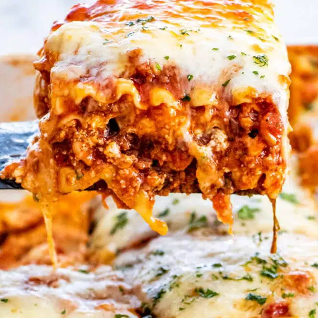 a spatula lifting a piece of lasagna from a casserole dish.