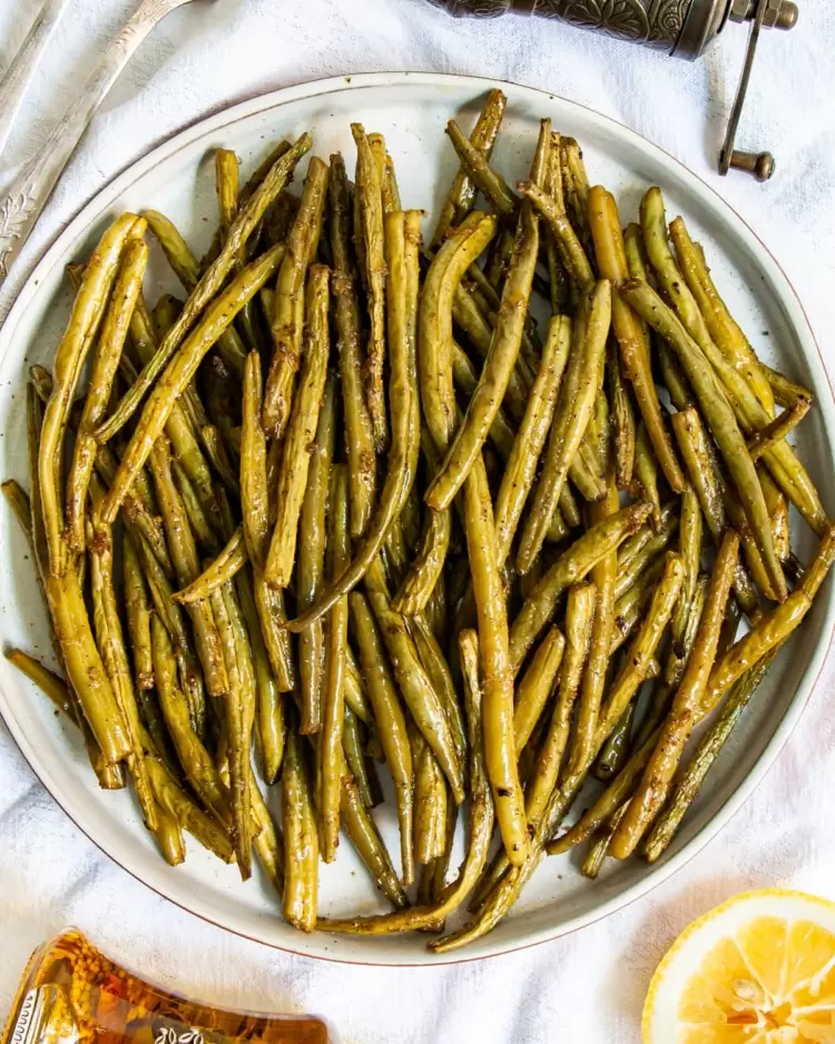 overhead shot of roasted green beans on a plate