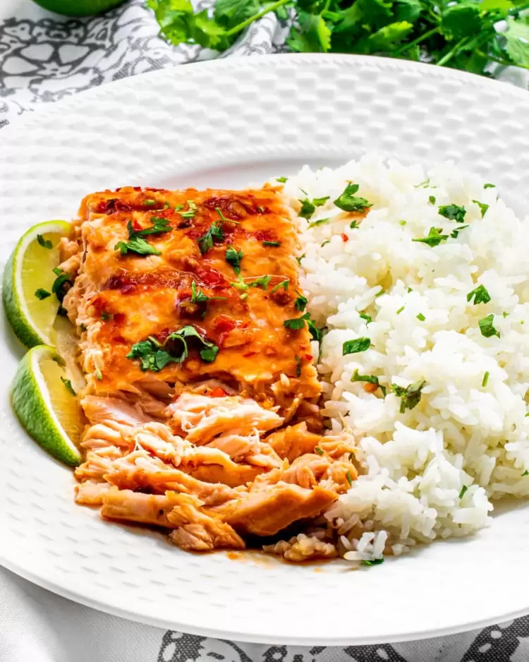 flaked thai salmon next to rice on a white plate