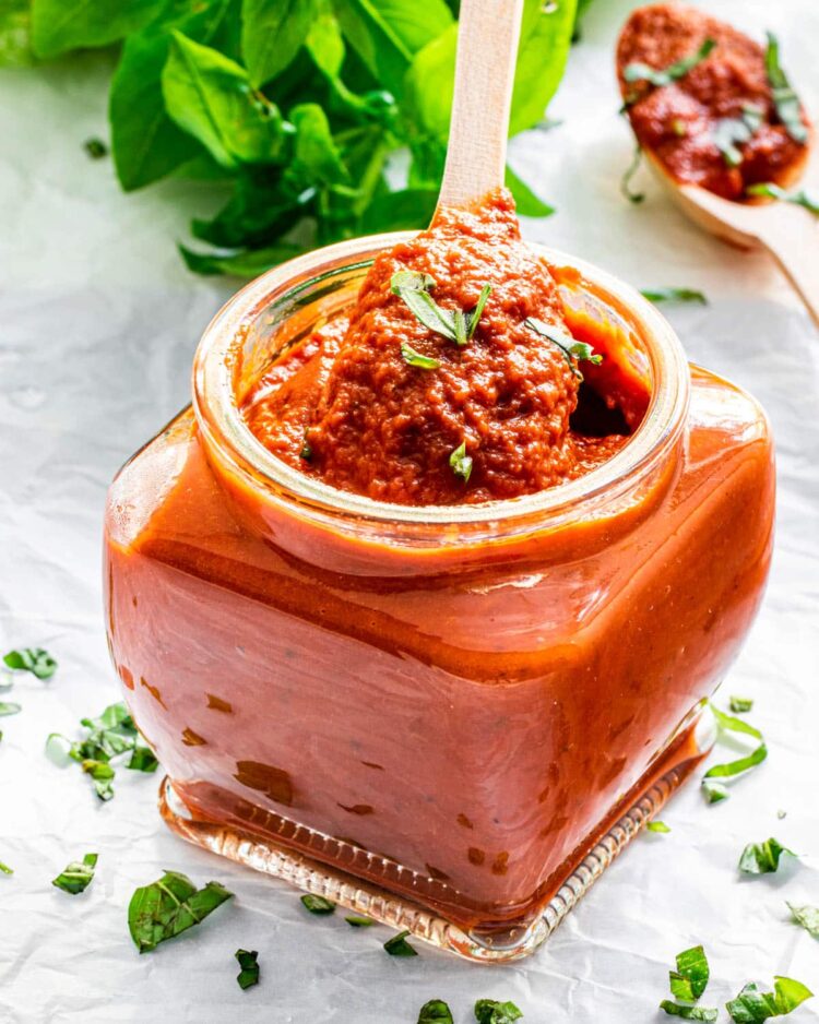 a jar with marinara sauce and a spoon inside