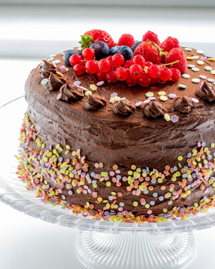 a beautiful frosted chocolate cake and topped with sprinkles and berries