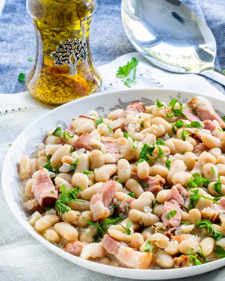 tuscan white beans in a white plate garnished with parsley
