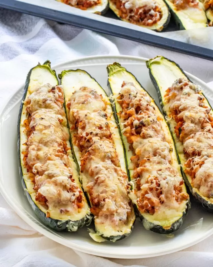 stuffed zucchini boats on a white plate
