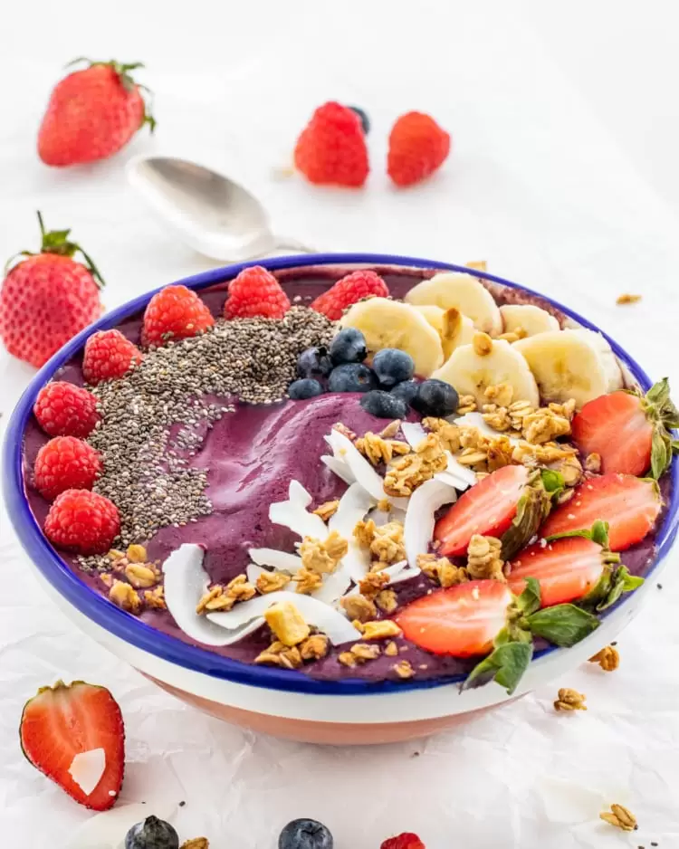 an açai bowl topped with berries and banana 