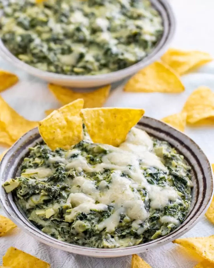 spinach dip in a bowl with tortilla chips