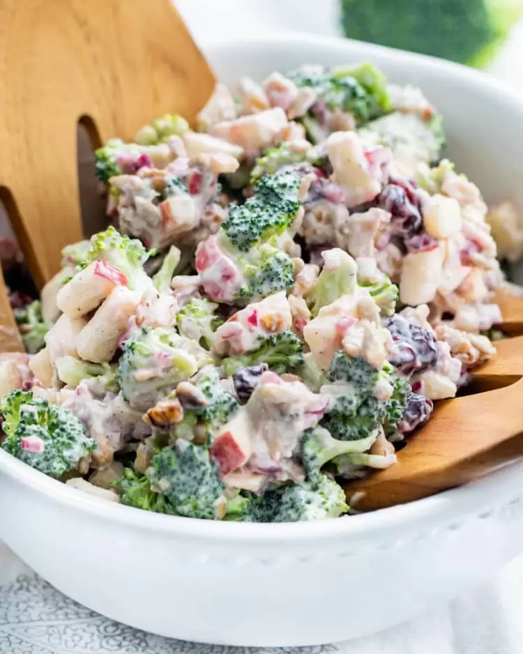 a white bowl loaded with broccoli salad