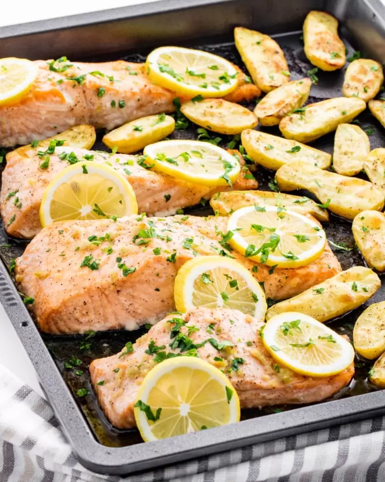 garlic butter baked salmon and fingerling potatoes on a baking sheet