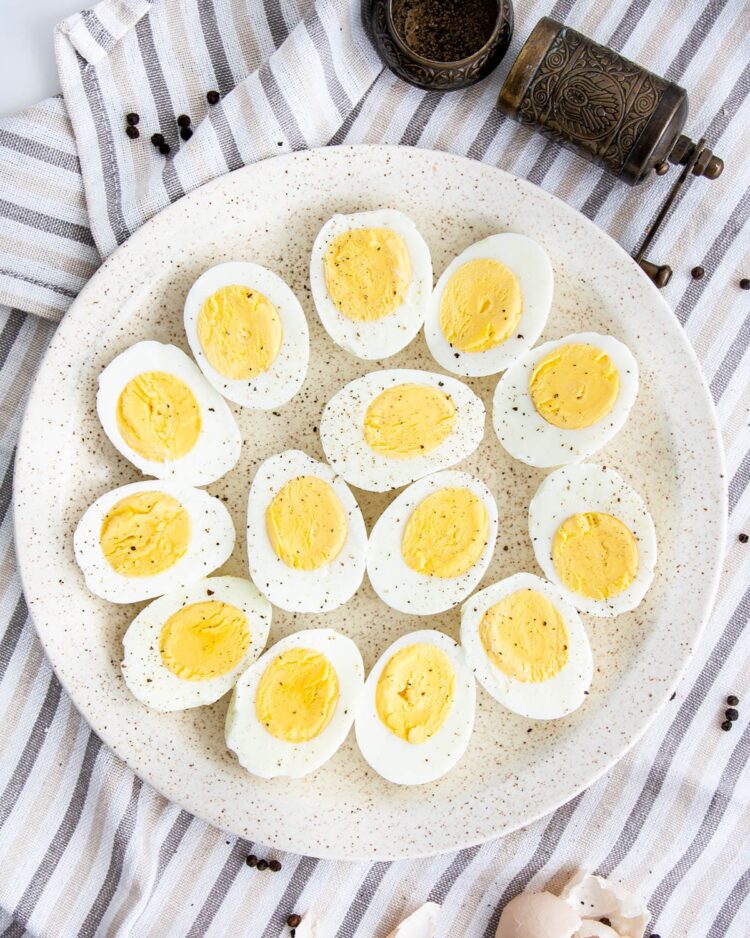 overhead shot of hard boiled eggs cut in half on a white plate