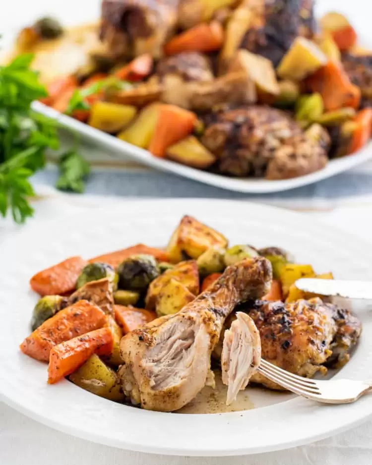 roasted chicken with roasted vegetables on a white plate