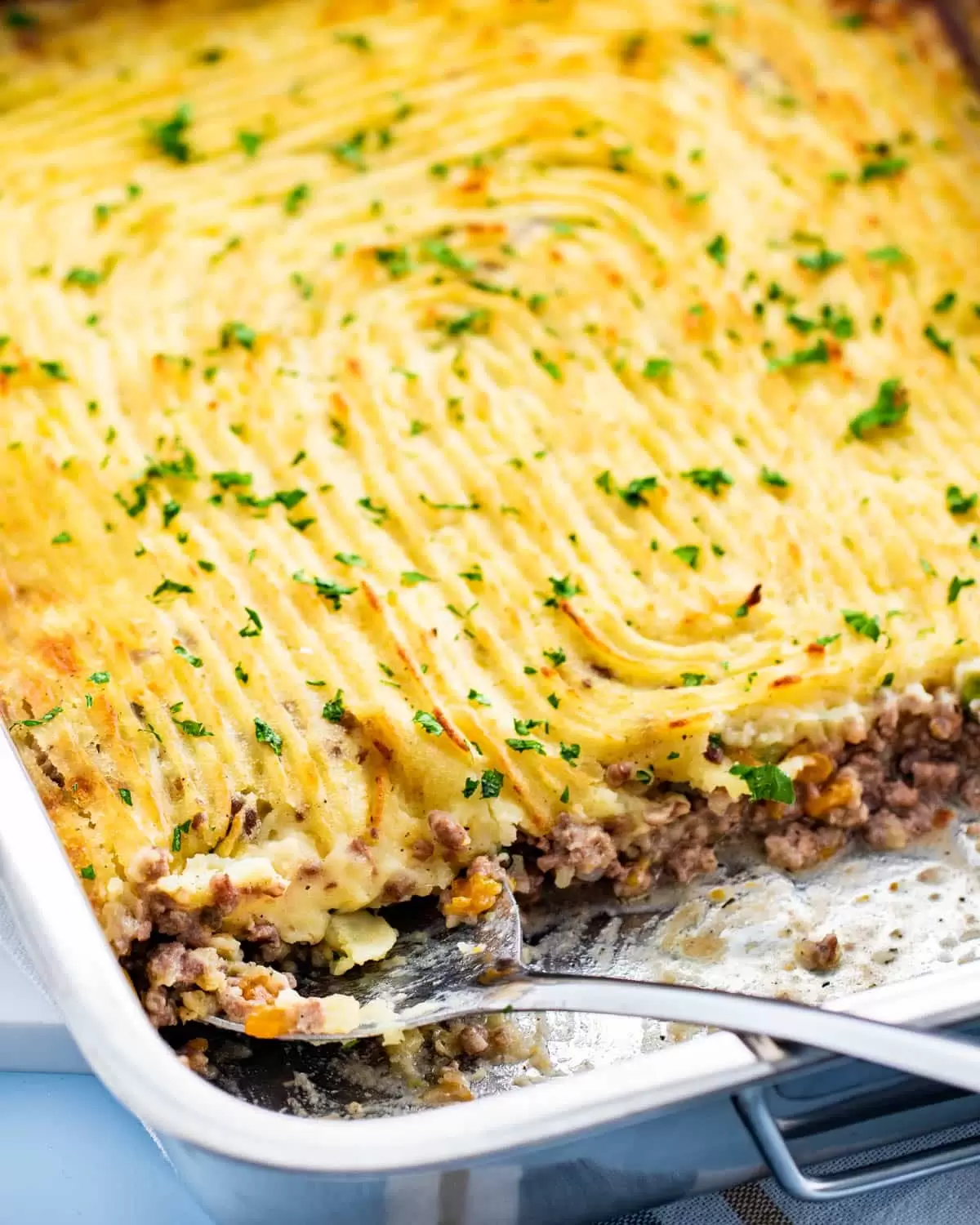 a casserole dish with freshly made shepherd's pie garnished with parsley