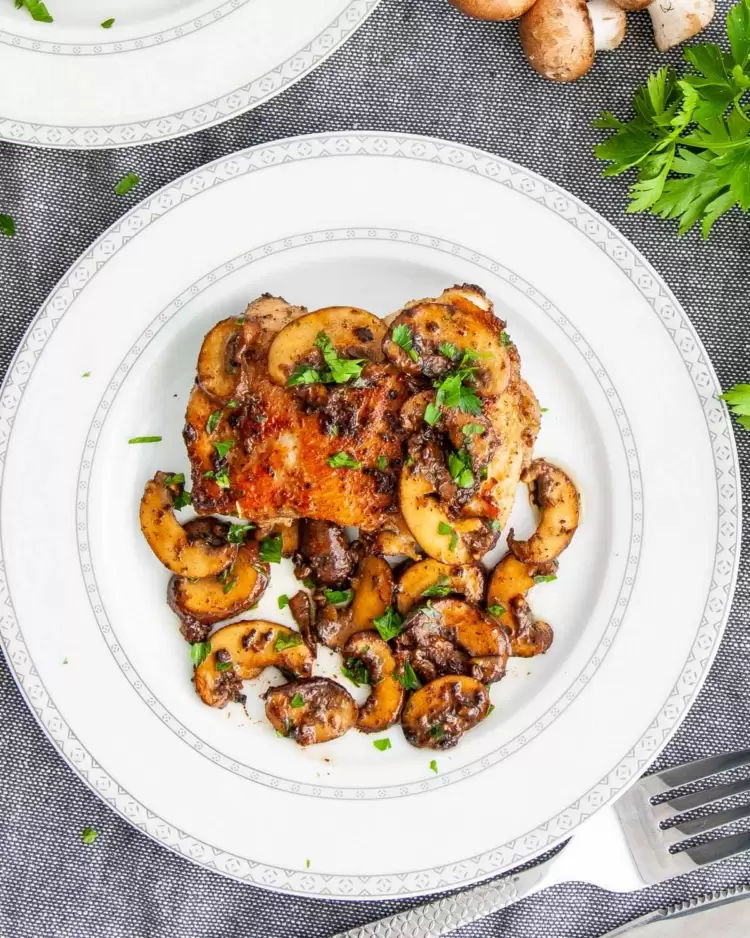 chicken and mushrooms in a white plate