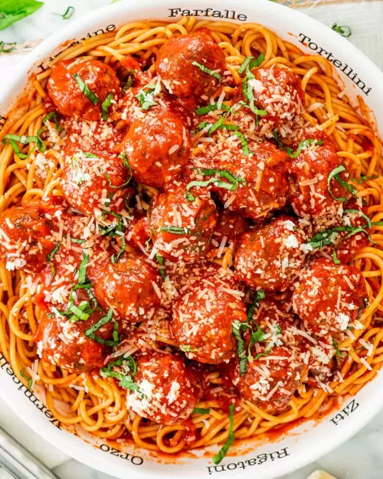 overhead shot of spaghetti and meatballs in a large white pasta bowl