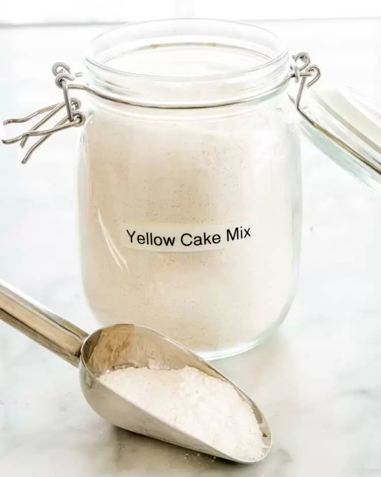 yellow cake mix in a jar with a scoop of the mix next to it