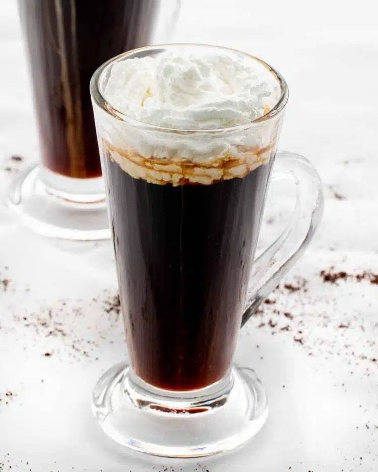 a glass cup with irish coffee topped with whipped cream