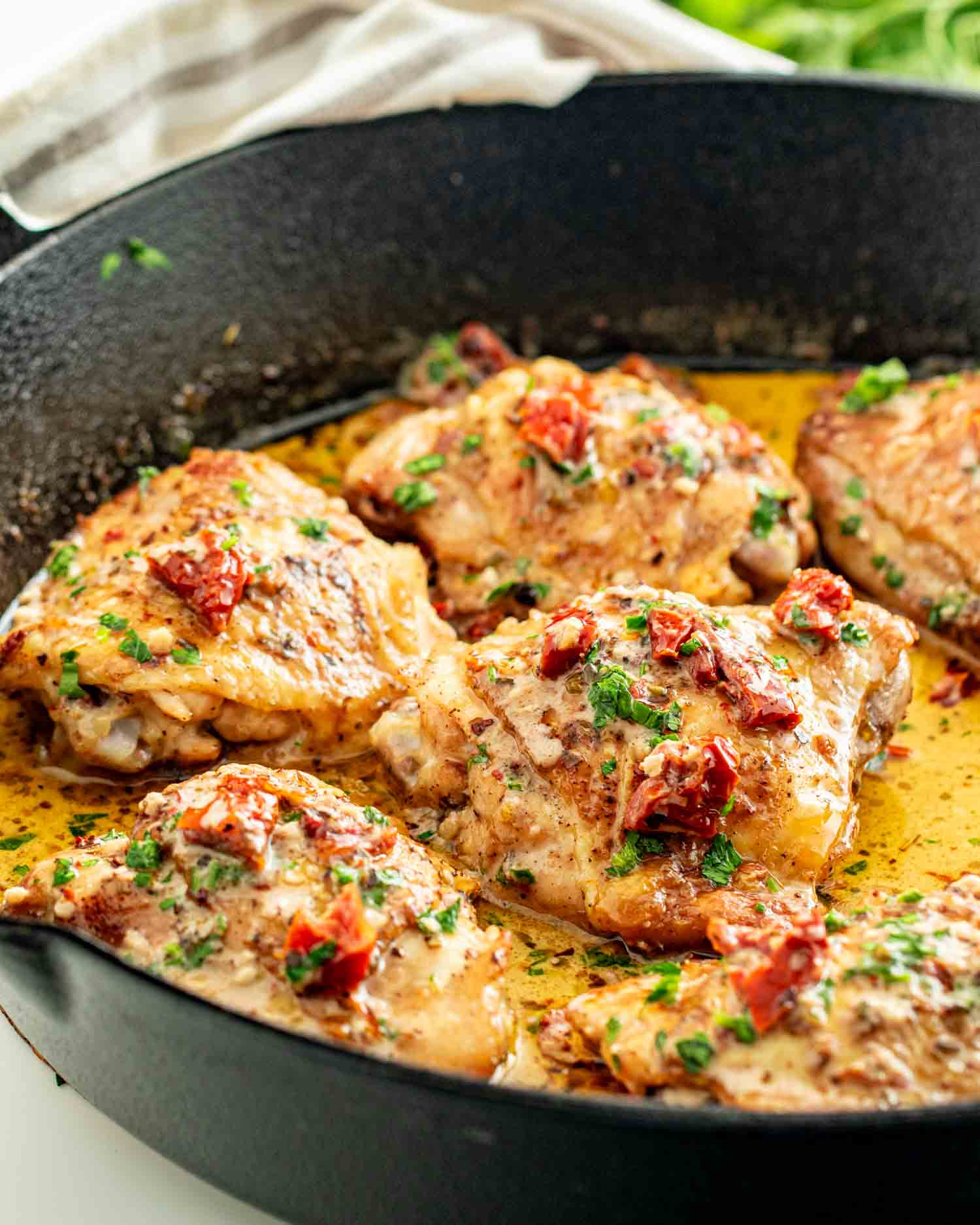 freshly made marry me chicken in a cast iron skillet garnished with parsley.