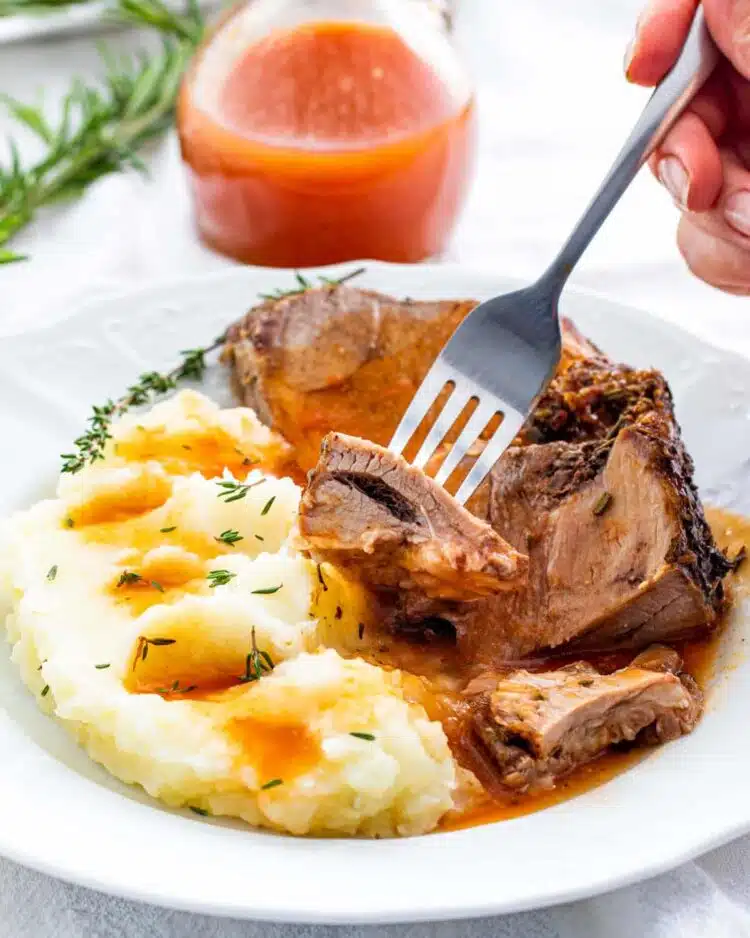 a slice of roast leg of lamb with mashed potatoes and gravy