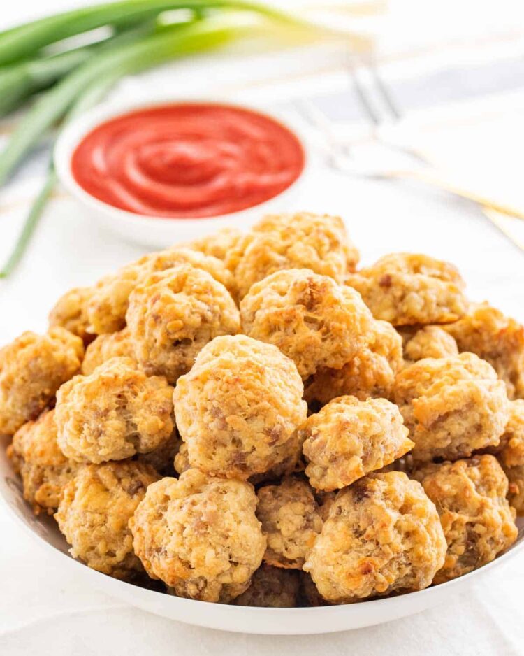 sausage balls in a bowl with ketchup in the background