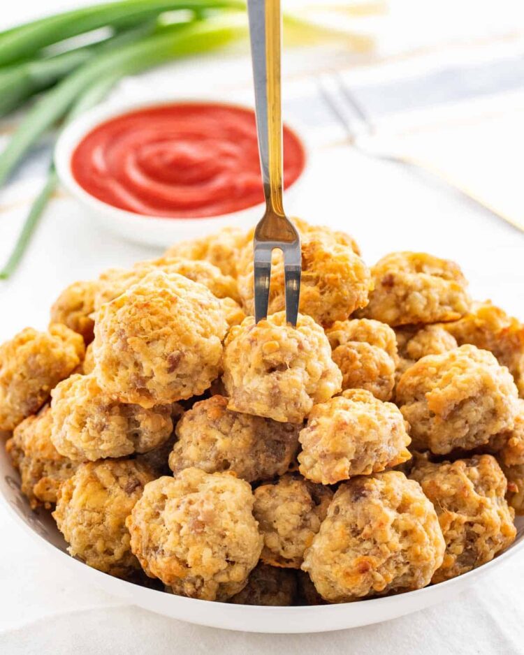 a bowl of sausage balls with a fork stuck in a ball