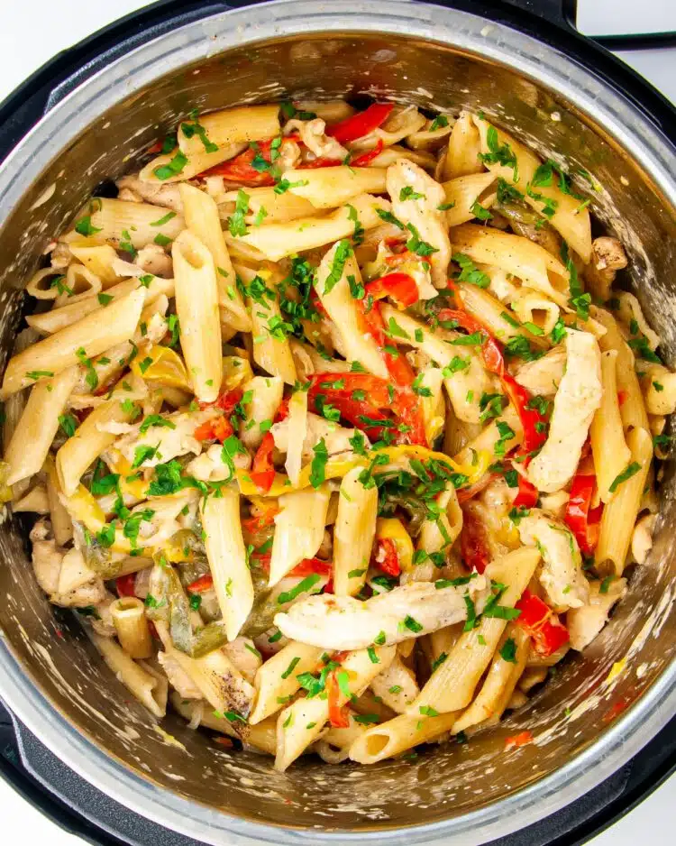 overhead shot of freshly made chicken fajita pasta in an instant pot garnished with a bit of cilantro
