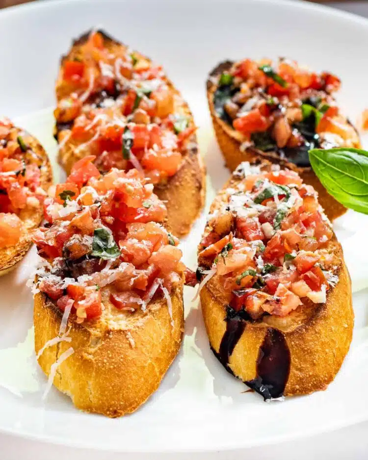 sideview shot of a few bruschetta slices on a white plate