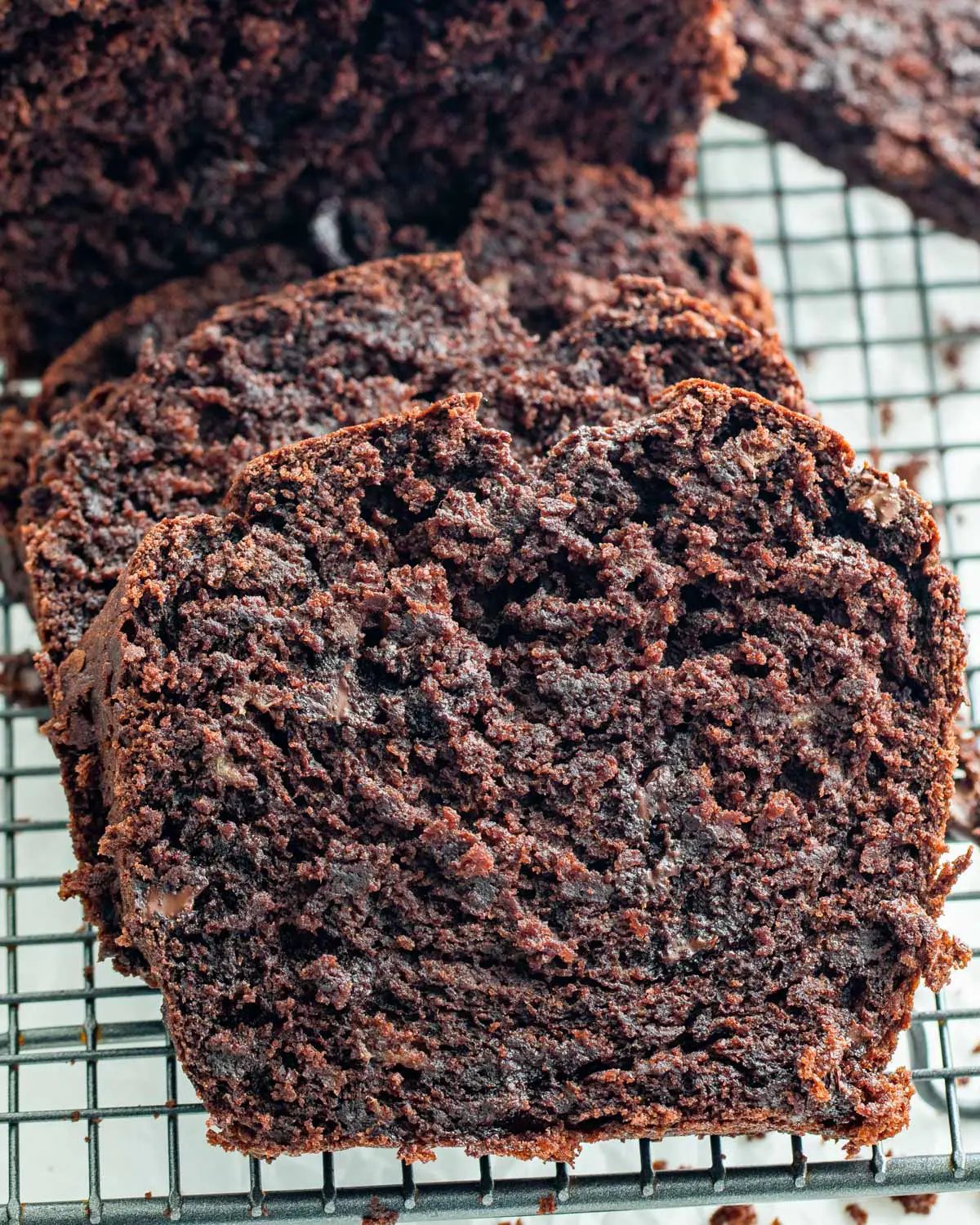 side view shot of a couple slices of chocolate banana bread on a cooling rack