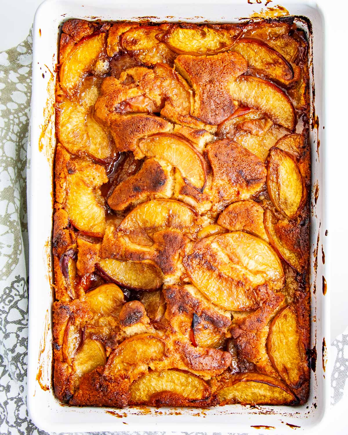 overhead shot of a peach cobbler in a baking dish fresh out of the oven