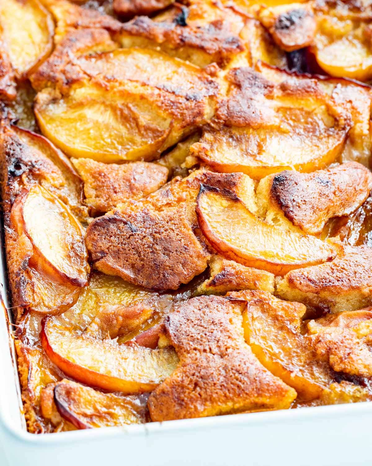 side view shot of a peach cobbler fresh out of the oven in a baking dish