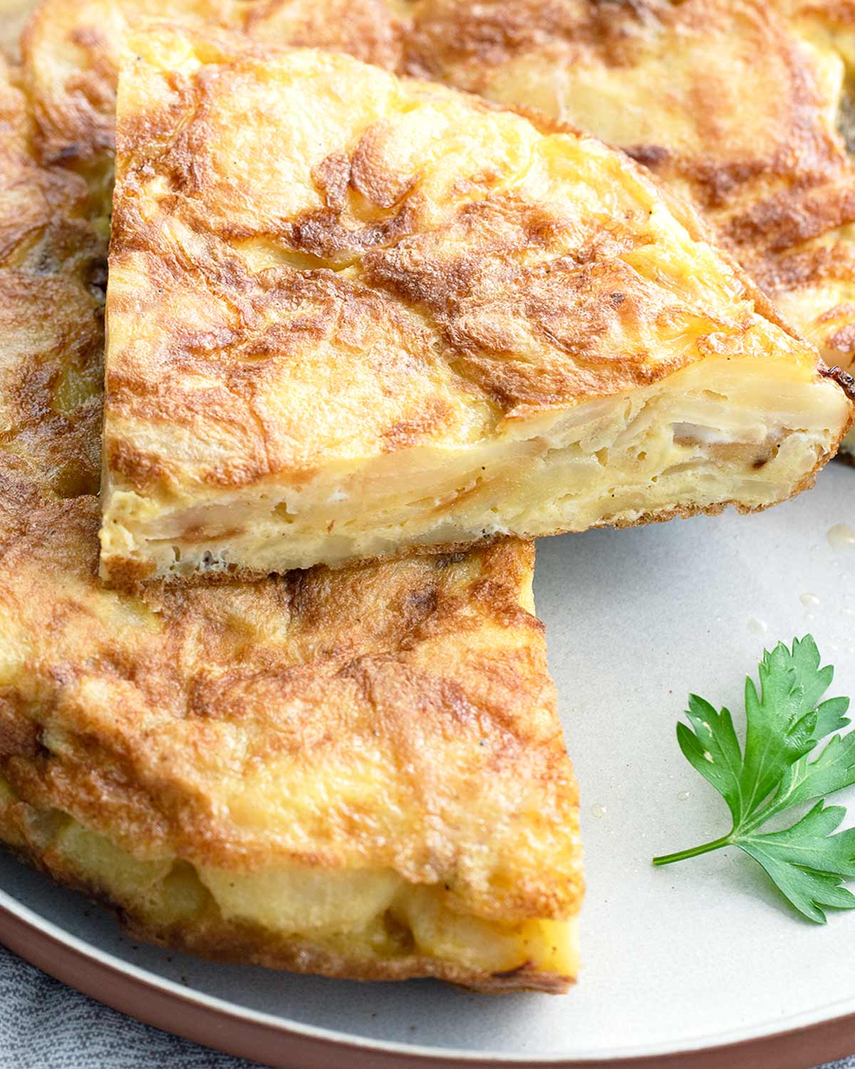 spanish tortilla on a plate with a slice on top.