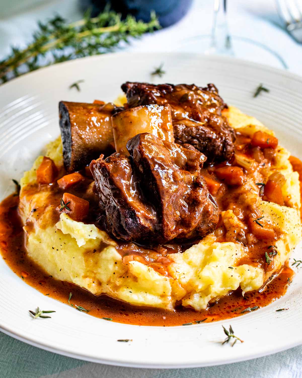 2 beef short ribs on a bed of mashed potatoes.
