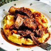 2 beef short ribs on a bed of mashed potatoes.